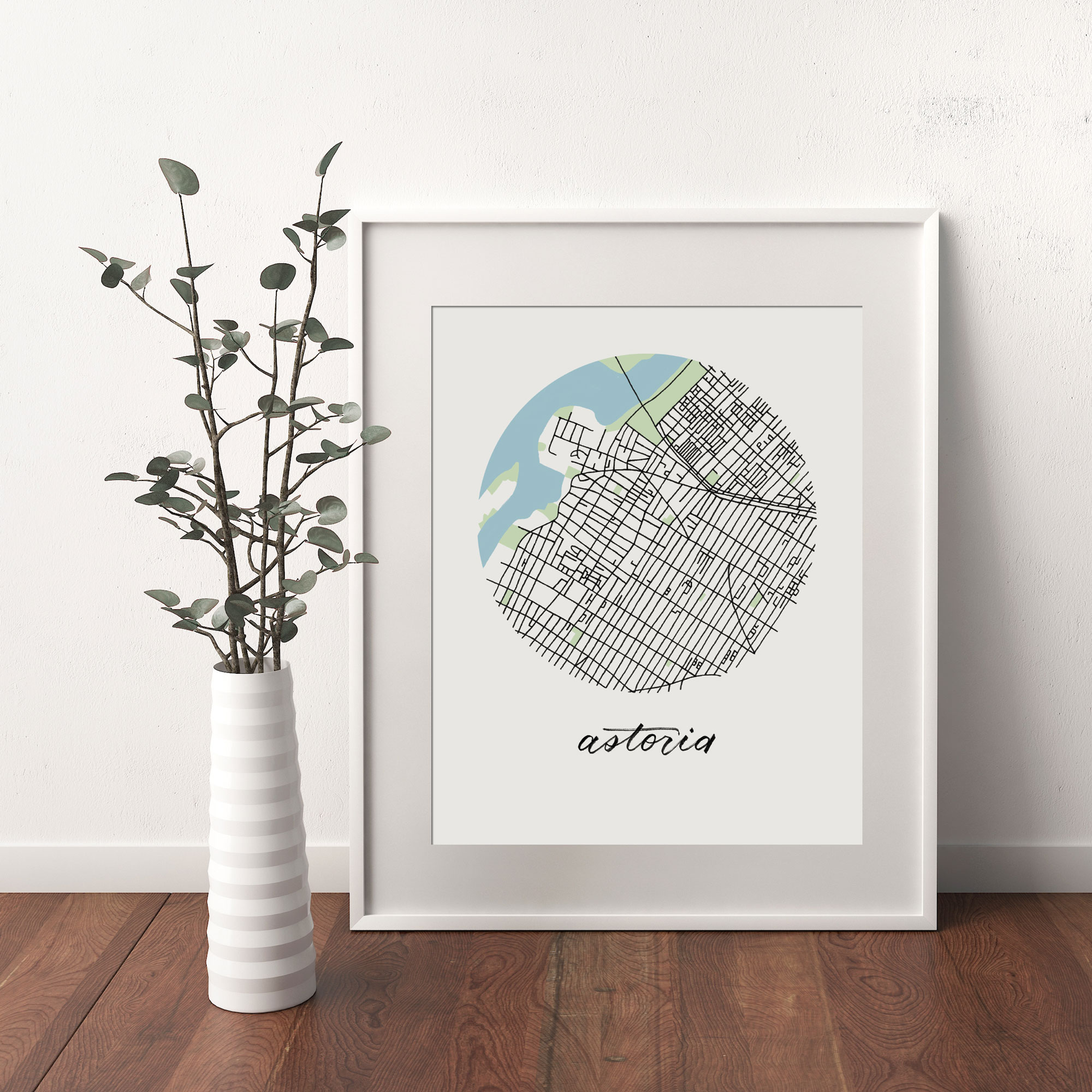Astoria, Queens Map print framed and leaning on white wall next to dried leaves in a vase